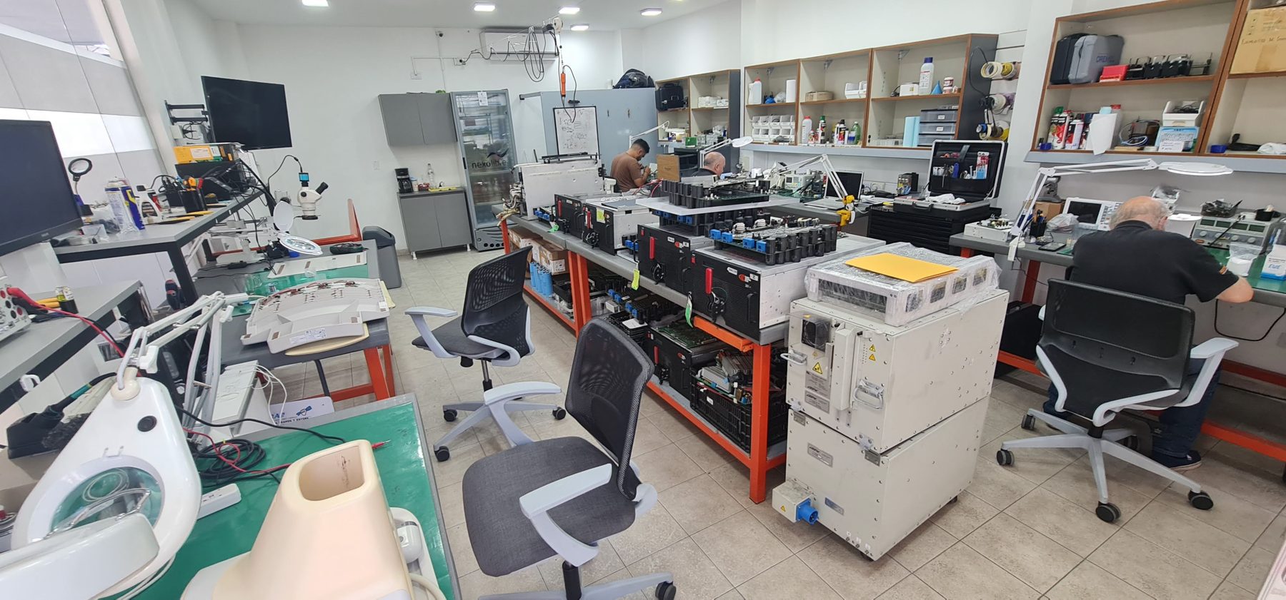 Técnicos reparando y testeando partes de MRI/CT en el laboratorio de Argentina